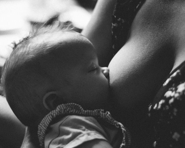 mom feeding baby and learning how to travel with breast milk