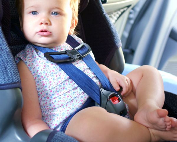 Baby happily sitting and flying with car seat
